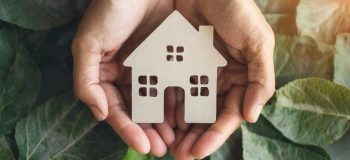 hands cradling paper house symbolizing shelter, family, homelessness, and home innovation hands cradling paper house symbolizing shelter, family, homelessness, and home innovation